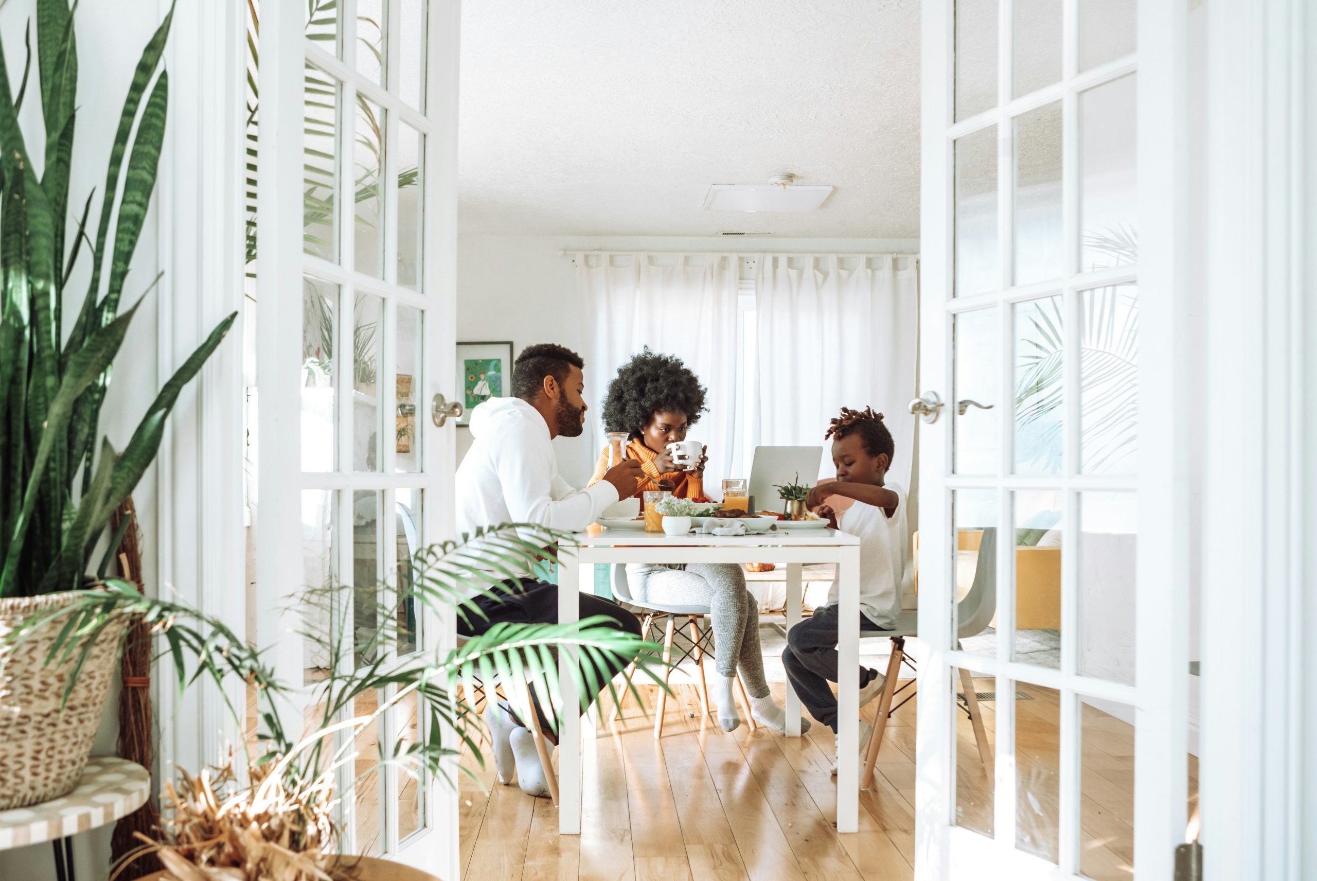 Bright dining space with plants and people eating together