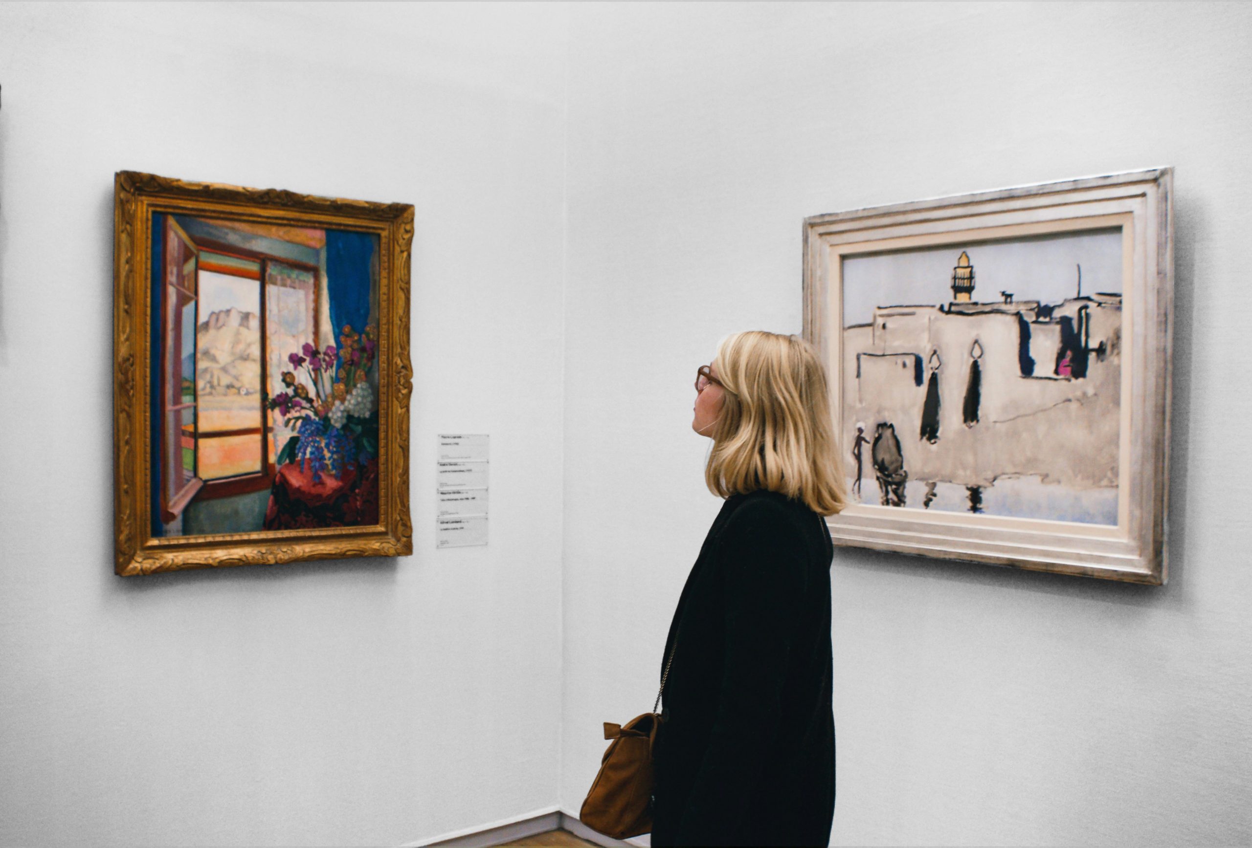Person viewing framed artwork in a gallery